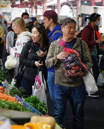 AUSTRALIA CORONAVIRUS COVID-19, People shop at the Queen Victoria Market while wearing face masks as a preventive measure against the spread of novel coronavirus COVID-19 in Melbourne, Saturday, April 11, 2020. Authorities have said social distancing and isolation measures could still remain in place for the next six months. A shutdown of non-essential services is in effect Australia wide in a bid to slow the spread of the coronavirus (COVID-19) disease. ( NO ARCHIVING, EDITORIAL USE ONLY, NO USE IN BOOKS WITHOUT CONSENT MELBOURNE VIC AUSTRALIA  Copyright: xSCOTTxBARBOURx 20200411001463007139