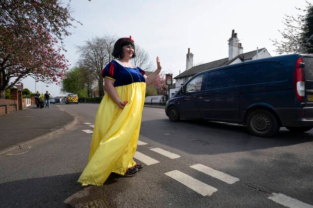 (200411) -- STOCKPORT, April 11, 2020 -- Rebecca Williamson, a girl dressed in Snow White costumes, cheers up people amid the COVID-19 pandemic in Stockport near Manchester, Britain, on April 10, 2020. Rebecca, one of those who dressed as comic books or fairytale characters, attempted to cheer up people in the public during the epidemic outbreak. (Photo by Xinhua) UK-STOCKPORT-COVID-19-SNOW WHITE JonxSuper 