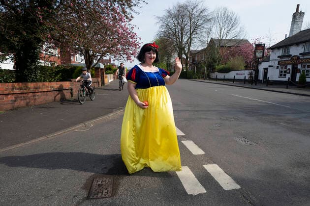 (200411) -- STOCKPORT, April 11, 2020 -- Rebecca Williamson, a girl dressed in Snow White costumes, cheers up people amid the COVID-19 pandemic in Stockport near Manchester, Britain, on April 10, 2020. Rebecca, one of those who dressed as comic books or fairytale characters, attempted to cheer up people in the public during the epidemic outbreak. (Photo by Xinhua) UK-STOCKPORT-COVID-19-SNOW WHITE JonxSuper 