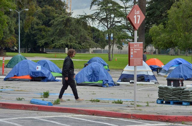 A veteran walks amongst homeless tents in a parking lot at the West Los Angeles VA Medical Center during the coronavirus pandemic in Los Angeles on Friday, April 10, 2020.  LAP2020041010 JIMxRUYMEN
