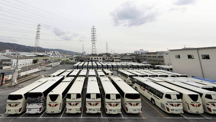 New coronavirus Photo taken in Higashiosaka, Osaka Prefecture, western Japan, on April 11, 2020, shows tour buses at a depot, which have been stranded since mid-March as people have shunned bus tours amid a surge in coronavirus infections. 