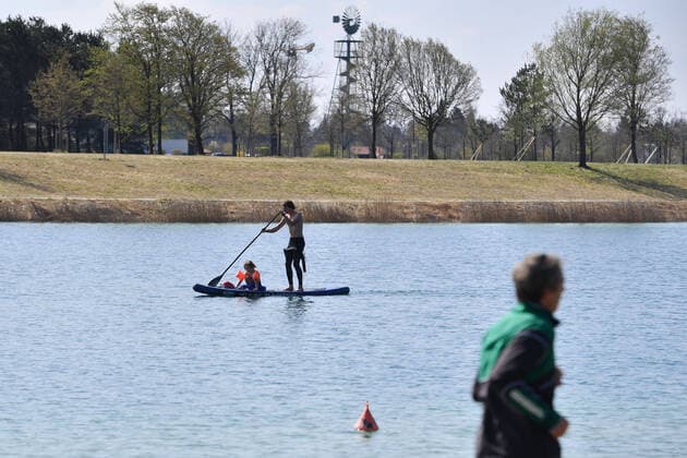 Easter in times of the Corona Pandemic public life on 11 04 2020 at the Buga Lake in Riemer Park A father paddles together with his child, who is sitting in front of him on a board, over the lake Stand Up Paddling Stand Up Paddler The spring weather drives the population to fresh air, always with the necessary distance because of an infection with the corona virus