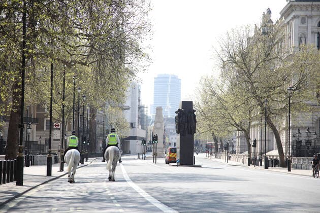 Day Nineteen of Lockdown in London. A pair of mounted police officers walk along a deserted Whitehall in London on Easter Saturday. It is the first public holiday of the year, and many people enjoy the long weekend by going out and about or on holiday, but this year the country is on lockdown due to the COVID-19 Coronavirus pandemic. People are not allowed to leave home except for minimal food shopping, medical treatment, exercise - once a day, and essential work. COVID-19 Coronavirus lockdown, London, UK, on April 11, 2020 