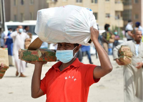 (200411) -- AHMADI GOVERNORATE, April 11, 2020 (Xinhua) -- A resident of area of Mahboula carries food distributed by the government after the area was locked down to curb the spread of novel coronavirus, in Ahmadi Governorate, Kuwait, April 11, 2020. The Kuwaiti government has decided to impose a complete lockdown on the areas of Mahboula and Jleeb Al-Shuyoukh for two weeks. Kuwait reported on Saturday 161 new COVID-19 cases, bringing the total number of confirmed cases in the country to 1,154, the Health Ministry said in a statement. (Photo by Asad Xinhua) KUWAIT-AHMADI GOVERNORATE-FOOD DISTRIBUTION 