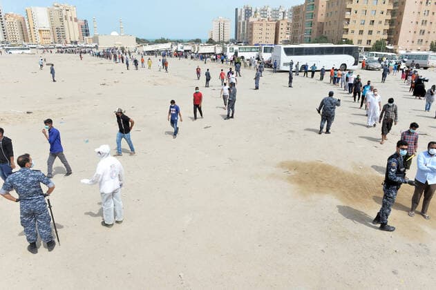 (200411) -- AHMADI GOVERNORATE, April 11, 2020 (Xinhua) -- Residents of area of Mahboula queue up to receive food after the area was locked down by the government to curb the spread of novel coronavirus, in Ahmadi Governorate, Kuwait, April 11, 2020. The Kuwaiti government has decided to impose a complete lockdown on the areas of Mahboula and Jleeb Al-Shuyoukh for two weeks. Kuwait reported on Saturday 161 new COVID-19 cases, bringing the total number of confirmed cases in the country to 1,154, the Health Ministry said in a statement. (Photo by Asad Xinhua) KUWAIT-AHMADI GOVERNORATE-FOOD DISTRIBUTION 