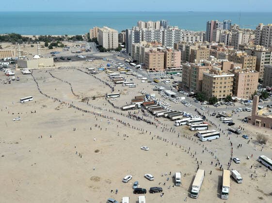 (200411) -- AHMADI GOVERNORATE, April 11, 2020 (Xinhua) -- Residents of area of Mahboula queue up to receive food after the area was locked down by the government to curb the spread of novel coronavirus, in Ahmadi Governorate, Kuwait, April 11, 2020. The Kuwaiti government has decided to impose a complete lockdown on the areas of Mahboula and Jleeb Al-Shuyoukh for two weeks. Kuwait reported on Saturday 161 new COVID-19 cases, bringing the total number of confirmed cases in the country to 1,154, the Health Ministry said in a statement. (Photo by Asad Xinhua) KUWAIT-AHMADI GOVERNORATE-FOOD DISTRIBUTION 