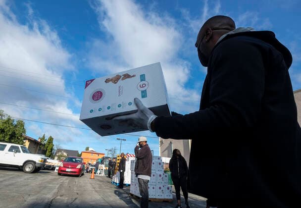 April 11, 2020, Los Angeles, California, U.S: A staff holds a box of diapers during a drive thru grab-and-go distribution of diapers to assist families in need during the COVID-19 outbreak on Saturday April 11, 2020, in Los Angeles. Los Angeles U.S. - ZUMAc68_ 20200411_zaf_c68_002 Copyright: xRingoxChiux