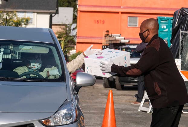 April 11, 2020, Los Angeles, California, U.S: A staff hands a box of diapers to a driver during a drive thru grab-and-go distribution of diapers to assist families in need during the COVID-19 outbreak on Saturday April 11, 2020, in Los Angeles. Los Angeles U.S. - ZUMAc68_ 20200411_zaf_c68_003 Copyright: xRingoxChiux