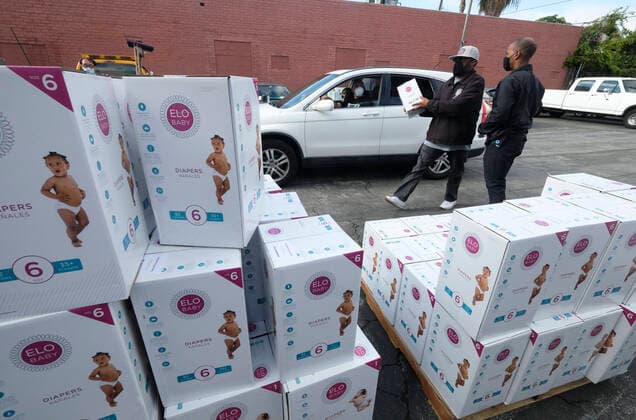 April 11, 2020, Los Angeles, California, U.S: A staff hands a box of diapers to a driver during a drive thru grab-and-go distribution of diapers to assist families in need during the COVID-19 outbreak on Saturday April 11, 2020, in Los Angeles. Los Angeles U.S. - ZUMAc68_ 20200411_zaf_c68_005 Copyright: xRingoxChiux