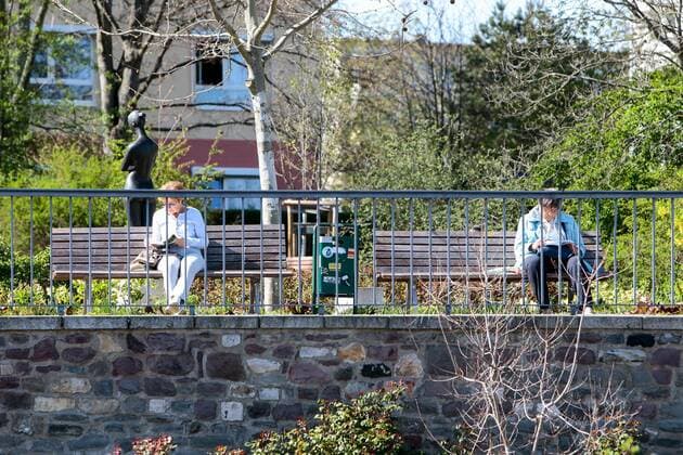 11 04 2020, xtgx, Effects of the corona virus in Magdeburg, two senior citizens read with a large distance on parking benches Buecher Magdeburg