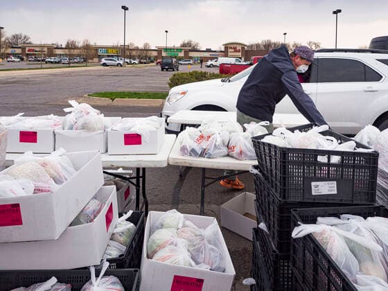 April 11, 2020, Des Moines, Iowa, U.S: JORDON ELWELL, owner and CEO of Midwest Foods, uses a plastic table to pass a ready to cook pasta meal to a motorist during a food distribution in Des Moines. Most non-essential businesses in Iowa are closed until 30 April. Because of business closings causes by the Novel Coronavirus (SARS-CoV-2) pandemic, well over 100,000 Iowans filed first time claims for unemployment in the last three weeks, more than applied during the peak of the Great Recession of 2008. Local food banks have seen an unprecedented spike in people seeking nutritional assistance. Midwest Foods, a Des Moines based company and owner of Ginos Fine Italian Foods, gave away 1,000 complete dinners with sauce, noodles, salad, and dressing Saturday morning. People started lining up 3 hours before the food distribution began. The food dis - ZUMAk94_ 20200411_zaf_k94_004 Copyright: xJackxKurtzx