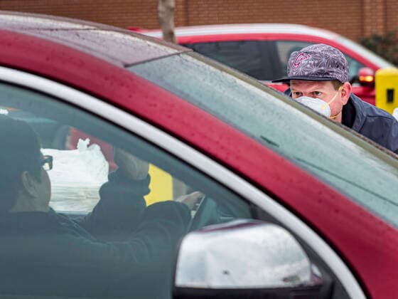 April 11, 2020, Des Moines, Iowa, U.S: JORDON ELWELL, owner and CEO of Midwest Foods, talks to a passing motorist during a food distribution in Des Moines. Most non-essential businesses in Iowa are closed until 30 April. Because of business closings causes by the Novel Coronavirus (SARS-CoV-2) pandemic, well over 100,000 Iowans filed first time claims for unemployment in the last three weeks, more than applied during the peak of the Great Recession of 2008. Local food banks have seen an unprecedented spike in people seeking nutritional assistance. Midwest Foods, a Des Moines based company and owner of Ginos Fine Italian Foods, gave away 1,000 complete dinners with sauce, noodles, salad, and dressing Saturday morning. People started lining up 3 hours before the food distribution began. The food distribution was done following social dist - ZUMAk94_ 20200411_zaf_k94_008 Copyright: xJackxKurtzx