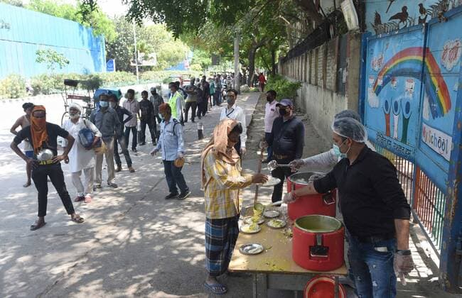 Coronavirus in Indien, Eindrücke aus Neu-Delhi NEW DELHI, INDIA - APRIL 11: People at a food distribution by the Delhi government, on day eighteen of the 21 day lockdown to limit the coronavieus, at Deen Dayal Upadhyay Marg, on April 11, 2020 in New Delhi, India. (Photo by Sonu Mehta Hindustan Times ) Government And NGOs Provide Food To Homeless And Poor Amid Lockdown To Prevent Covid-19