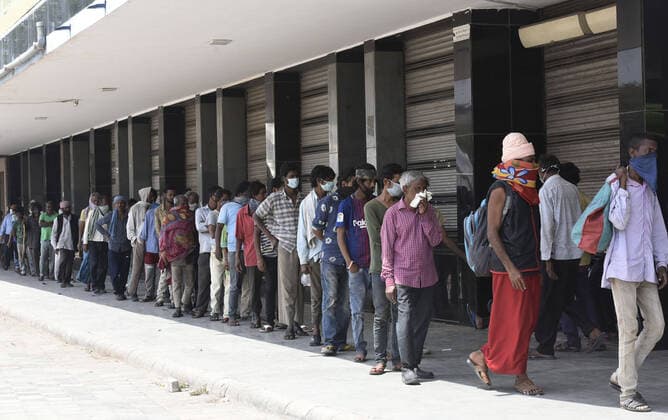 News Bilder des Tages Coronavirus in Indien, Eindrücke aus Neu-Delhi NEW DELHI, INDIA - APRIL 11: Homeless people and stranded migrant workers wait to collect food during a community feeding session , on the day eighteen of the 21-day nationwide lockdown to curb the spread of coronavirus, on April 11, 2020 in New Delhi, India. (Photo by Vipin Kumar Hindustan Times ) Government And NGOs Provide Food To Homeless And Poor Amid Lockdown To Prevent Covid-19