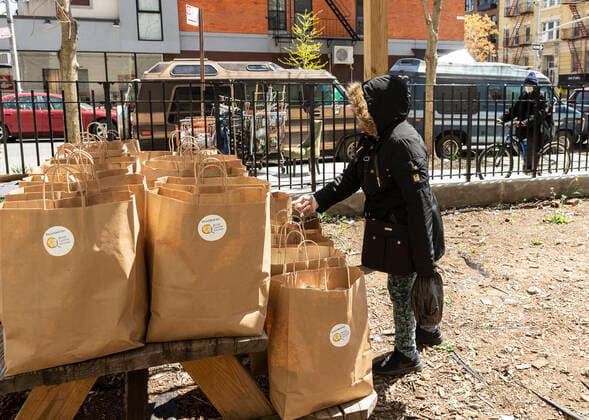 Coronavirus in den USA, Initiative in New York verteilt Essen an Bedürftige Struggling in NYC amid COVID-19 pandemic A woman picks up bag of free food amid COVID-19 pandemic prepared by World Central Kitchen non-profit organization created by Jose Andres the world renowned chef. Food pantries have been opened in many poor neighborhoods of the city the most hit by epidemic New York New York United States Copyright: LevxRadin