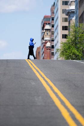 (200411) -- WASHINGTON, April 11, 2020 -- A woman crosses a street in Washington D.C., the United States, April 11, 2020. The total number of deaths due to COVID-19 in the United States topped 20,000 Saturday afternoon, according to data compiled by the Center for Systems Science and Engineering (CSSE) at Johns Hopkins University. ) U.S.-WASHINGTON D.C.-COVID-19-DEATH TOLL LiuxJie 