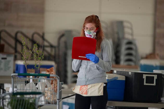 April 11, 2020, Bloomington, Indiana, United States: A worker wearing a face mask prepares an internet order for customers of the Bloomington Community Farmers Market where food is being distributed in a drive-thru arrangement at the Switchyard Pavilion. Bloomington United States - ZUMAs197 20200411_zaa_s197_174 Copyright: xJeremyxHoganx