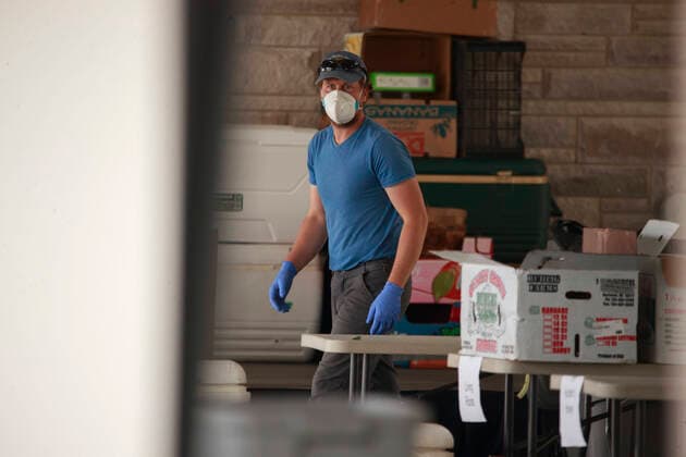 April 11, 2020, Bloomington, Indiana, United States: A worker wearing a face mask prepares an internet order for customers of the Bloomington Community Farmers Market where food is being distributed in a drive-thru arrangement at the Switchyard Pavilion. Bloomington United States - ZUMAs197 20200411_zaa_s197_176 Copyright: xJeremyxHoganx