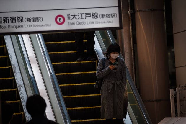 A girl wearing a mask is on a escalator in Shinjuku South area in Tokyo, Japan, 11 April 2020. Japanese Prime Minister Shinzo Abe declared a state of emergency for at least one month amid an increase of coronavirus and COVID-19 infection cases. April 11, 2020  (125267605)