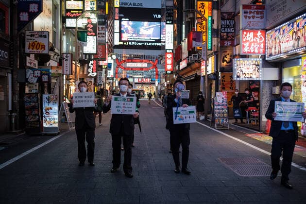 Tokyo city hall staff walk in Kabukicho (Shinjuku s red light district) with placard to ask people to stay home and take care of corona virus (also knows at Covid19) in Tokyo, Japan, 11 April 2020. Japanese Prime Minister Shinzo Abe declared a state of emergency for at least one month amid an increase of coronavirus and COVID-19 infection cases. April 11, 2020  (125267664)