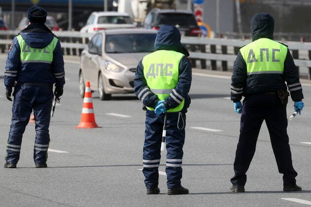 MOSCOW, RUSSIA - APRIL 12, 2020: Road police officers at an entrance to Moscow in Leninsky Prospekt Street. Police do not let cars registered in other regions, except for the Moscow Region, to enter the city as part of the measures to counter the spread of the COVID-19 coronavirus. Alexander Shcherbak TASS  TS0D5639