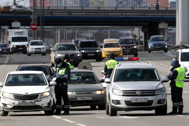 MOSCOW, RUSSIA - APRIL 12, 2020: Road police officers at an entrance to Moscow in Leninsky Prospekt Street. Police do not let cars registered in other regions, except for the Moscow Region, to enter the city as part of the measures to counter the spread of the COVID-19 coronavirus. Alexander Shcherbak TASS  TS0D563F