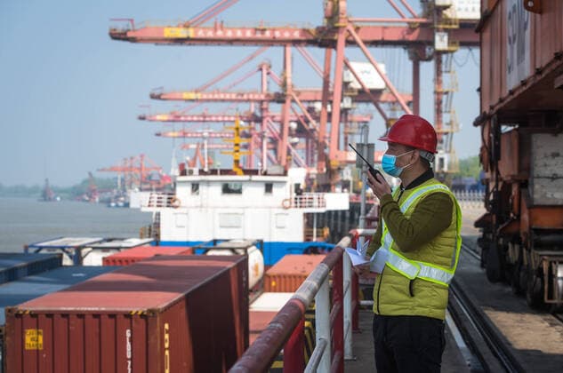 (200412) -- WUHAN, April 12, 2020 -- A staff member speaks to an intercom at the Yangluo Port in Wuhan, central China s Hubei Province, April 12, 2020. Wuhan, the megacity in central China, lifted outbound travel restrictions from April 8 after almost 11 weeks of lockdown to stem the spread of COVID-19. The cargos piled up at ports due to the COVID-19 pandemic have also been shipping away since the water ports in Wuhan resumed operation. ) CHINA-HUBEI-WUHAN-SHIPPING (CN) XiaoxYijiu 