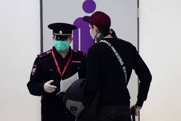 VLADIVOSTOK, RUSSIA - APRIL 12, 2020: A Russian citizen who has arrived from Seoul and a police officer at Vladivostok International Airport. Russia has suspended all international flights from March 27, 2020 due to the COVID-19 infection threat. Airlines are allowed to fly to other countries to evacuate Russian citizens. Yuri Smityuk TASS  TS0D569E