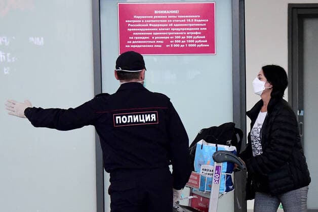 VLADIVOSTOK, RUSSIA - APRIL 12, 2020: A Russian citizen who has arrived from Seoul and a police officer at Vladivostok International Airport. Russia has suspended all international flights from March 27, 2020 due to the COVID-19 infection threat. Airlines are allowed to fly to other countries to evacuate Russian citizens. Yuri Smityuk TASS  TS0D56A1