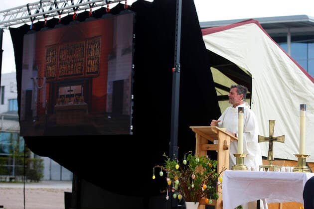 Erfurt, 12 04 2020 Pastor Christoph Knoll from the Thomas parish Erfurt holds the car Easter service on Easter Sunday on the grounds of the Erfurt trade fair Due to the corona crisis, no church services can be held at the moment The city of Erfurt has approved this type of service because a car is a closed room in which a maximum of 2 people can sit and the distance rule is thus observed