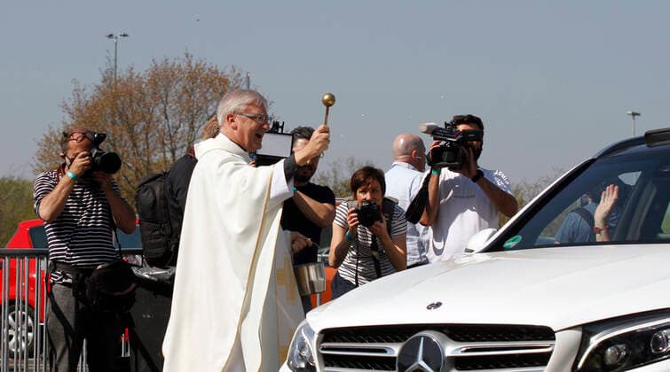12 04 2020, Catholic Easter Mass at the drive-in cinema in Düsseldorf, Düsseldorf city dean Frank Heidkamp blesses the cars as they leave the grounds after the service 12 04 2020, Catholic Easter Mass at the drive-in cinema in Düsseldorf 12 04 2020, Catholic Easter Mass at the drive-in cinema in Düsseldorf