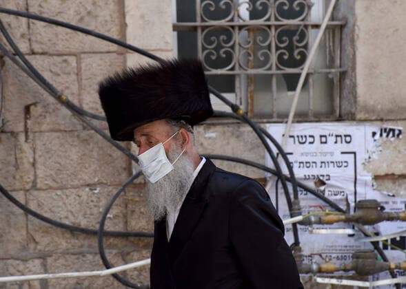 An Ultra-Orthodox Jew wears a mask, as protection against the coronavirus, in the Mea Shearim neighborhood, in Jerusalem, on Sunday, April 12, 2020. The Israeli government deployed a 1,000 police to enforce a full closure on Jewish religious neighborhoods with the highest rate of coronavirus in Jerusalem. According to the Health Ministry about 75 percent of the infected in Jerusalem live in the Ultra-Orthodox neighborhoods.  JER2020041211 DEBBIExHILL