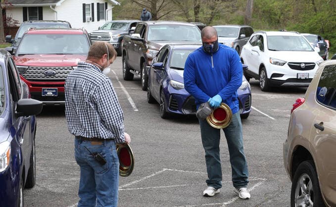 Ushers pray before collecting the offering at Easter Services at the Faith Baptist Church in St. Charles, Missouri on Sunday, April 12, 2020. The church held a parking lot service, keeping parishioners in their cars, listening to music and a sermon, honking their horns for approval.  SLP2020041214 BILLxGREENBLATT
