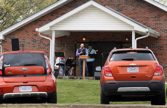 Parishioners listen to Easter Services from the comfort of their cars, at the Faith Baptist Church in St. Charles, Missouri on Sunday, April 12, 2020. The church held a parking lot service, keeping parishioners in their cars, listening to music and a sermon, honking their horns for approval.  SLP2020041217 BILLxGREENBLATT