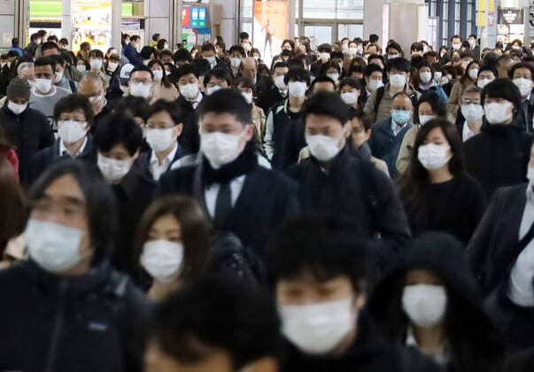 April 13, 2020, Tokyo, Japan - Commueters walk to their office in Tokyo on Monday, April 13, 2020. Japanese government asked to reduce person-to-person contact by up to 80 percent as Prime Minister Shinzo Abe declared a state of emergency to fight the new coronavirus.  (125288292)