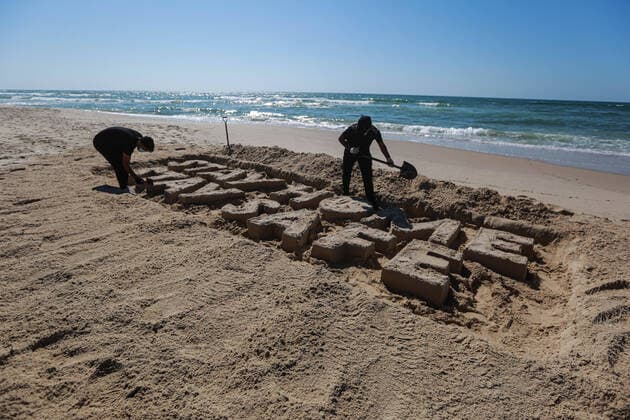 (200412) -- GAZA, April 12, 2020 (Xinhua) -- Palestinian artists carve words STAY HOME STAY SAFE with sand on a beach in Gaza City, on April 12, 2020. Palestine said on Sunday that the total number of COVID-19 cases in the country has reached 290. (Photo by Rizek Abdeljawad Xinhua) MIDEAST-GAZA CITY-COVID-19-SAND ART 