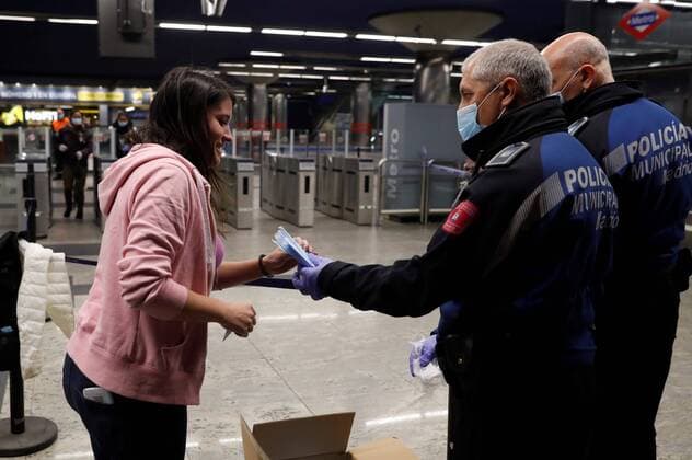 Policemen hand in masks to commuters at Nuevos Ministerios metro station in Madrid, as many return back to work in Madrid, Spain, 13 April 2020. Many people from various sectors return back to work as lockdown in Spain faces its fifth week in a bid to slow down the spread of the pandemic COVID-19 disease caused by the SARS-CoV-2. Police hand in masks at train and metro stations in Madrid !ACHTUNG: NUR REDAKTIONELLE NUTZUNG!  Copyright: xBallesterosx GRAF9825 20200413-637223637621928767