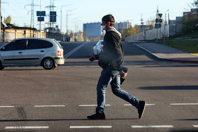 KYIV, UKRAINE - APRIL 12, 2020 - A man in a face mask crosses a street during quarantine amid the COVID-19 pandemic, Kyiv, capital of Ukraine. Daily life of Kyiv in quarantine  Copyright: xOvsyannikovaxYuliax