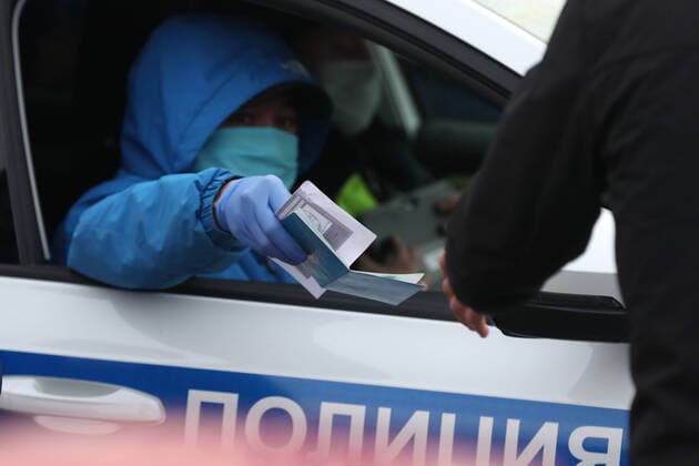 MOSCOW, RUSSIA - APRIL 13, 2020: A traffic police officer checks documents of drivers arriving from the direction of the Moscow Ring Road, entry into the city restricted to vehicles with number plates of other regions as part of additional preventive measures against the spread of the COVID-19 infection. Vladimir Gerdo TASS  TS0D5808