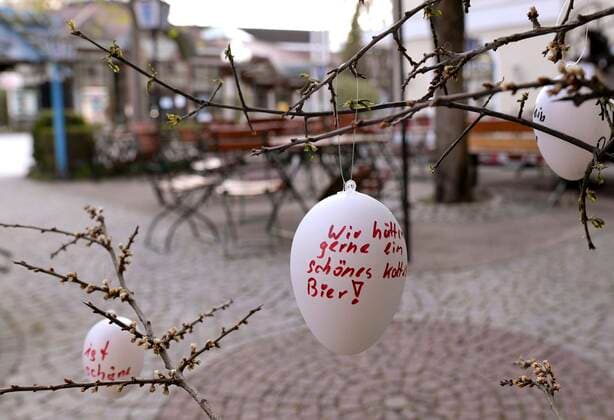13 04 2020, Shops and restaurants close due to corona virus pandemic in Bad Wörishofen, Tables and chairs in a beer garden currently without guests Guests have hung up Easter eggs with handwritten greetings we would like a nice cold beer 13 04 2020, Closed restaurants due to corona virus 13 04 2020, Closed restaurants due to corona virus