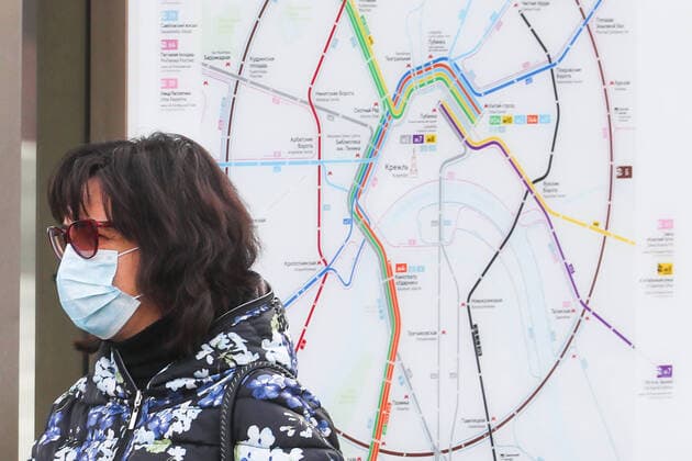 MOSCOW, RUSSIA - APRIL 13, 2020: A woman in a face mask stands next to a public transport traffic scheme; the Russian government has extended the period off work with full pay until April 30 nationwide to counter the spread of the COVID-19 infection. Alexander Shcherbak TASS  TS0D58E6