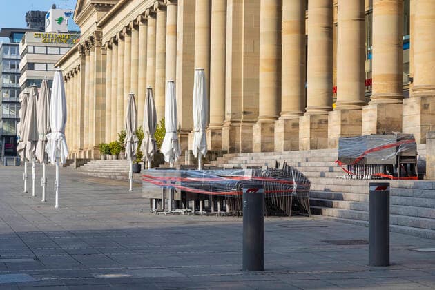 DEU, Germany, Baden Württemberg, Stuttgart, 13 04 2020 Shut down in Stuttgart The Corona Virus paralyses the state capital streets and squares are deserted pedestrian zone Königstraße with Königsbau chairs and tables of a street cafe are packed under a plastic tarpaulin