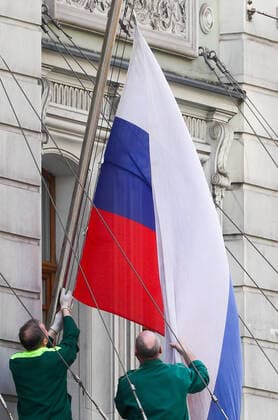 MOSCOW, RUSSIA - APRIL 13, 2020: Workers set up a Russian flag outside the Hotel Peter I. Alexander Shcherbak TASS  TS0D58F5