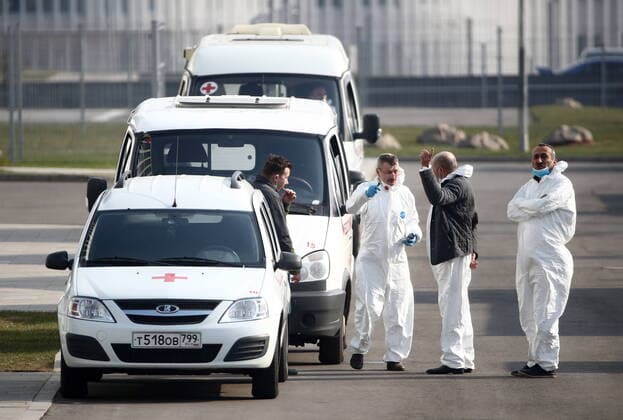MOSCOW, RUSSIA - APRIL 13, 2020: Ambulance vehicles and paramedics in protective gear at the Novomoskovsky multipurpose medical center for patients with suspected COVID-19 coronavirus infection. Valery Sharifulin TASS  TS0D5929