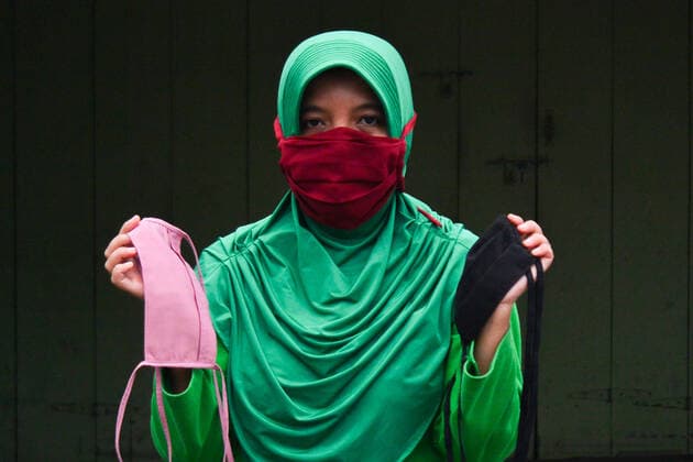 April 13, 2020, Blangpidie, Aceh, Indonesia: A woman holds free homemade cloth masks to be distributed to the people walking on the street..The Indonesian government requires people to wear masks whenever they are outside their homes in accordance with recommendations from the World Health Organization (WHO) to prevent the spread of COVID-19 in Indonesia. Blangpidie Indonesia - ZUMAs197 20200413_zaa_s197_047 Copyright: xMimixSaputrax