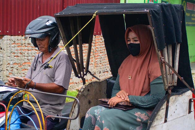 April 13, 2020, Blangpidie, Aceh, Indonesia: A passenger wearing a face mask as a precaution against the spread of coronavirus sits in a rickshaw..The Indonesian government requires people to wear masks whenever they are outside their homes in accordance with recommendations from the World Health Organization (WHO) to prevent the spread of COVID-19 in Indonesia. Blangpidie Indonesia - ZUMAs197 20200413_zaa_s197_048 Copyright: xMimixSaputrax