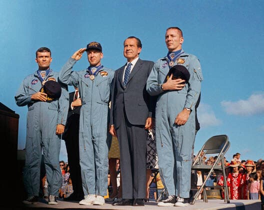President Richard M. Nixon and the Apollo 13 crew salute the U.S. flag during the post-mission ceremonies at Hickam Air Force Base, Hawaii. Earlier, astronauts John Swigert, Jim Lovell, and Fred W. Haise were presented the Presidential Medal of Freedom by the Chief Executive. Apollo 13, launched on April 11, 1970, was NASA s third crewed mission to the moon. Two days later, on April 13, while en route to the lunar surface, a fault in the electrical system of one of the Service Module s oxygen tanks produced an explosion that caused both oxygen tanks to fail and also led to a loss of electrical power. With the mission aborted, a dedicated team in the Apollo Mission Control Center devoted their efforts to developing a plan to shelter the crew in the lunar module as a lifeboat and retain sufficient resources to bring the spacecraft and its WAX2020041303 NASA