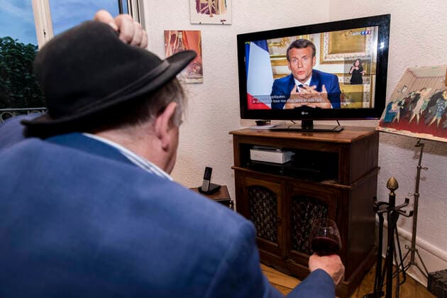 Chambery, France April 13, 2020 - A A confined French man in watching on television the speech of the French President Emmanuel Macron concerning the COVID19 health crisis ALLOCUTION, MACRON, PRESIDENT DE LA REPUBLIQUE, DISCOURS, COVID19, CRISE SANITAIRE, CONFINEMENT, SANTE, CORONAVIRUS, POLITIQUE Copyright: xVincentxIsorex