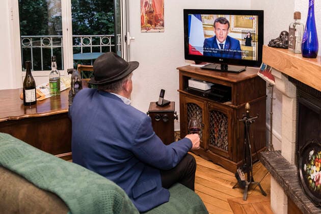 Chambery, France April 13, 2020 - A A confined French man in watching on television the speech of the French President Emmanuel Macron concerning the COVID19 health crisis ALLOCUTION, MACRON, PRESIDENT DE LA REPUBLIQUE, DISCOURS, COVID19, CRISE SANITAIRE, CONFINEMENT, SANTE, CORONAVIRUS, POLITIQUE Copyright: xVincentxIsorex