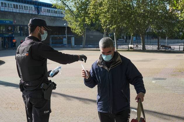 A police officer gives out free protective face masks during the lockdown amid the coronavirus disease COVID 19 outbreak in Madrid, Spain, April 13, 2020 Cordon Press